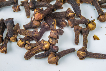 Spice carnations on a white kitchen table. Fragrant spices for gingerbread and mulled wine.
