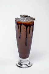 Iced chocolate in glass decorate with chocolate syrup on glass edge  on white background