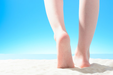 Little girl walks on the sandy beach, part of the body