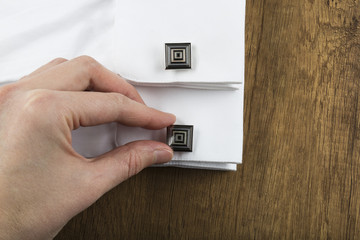 cufflinks with shirt on the wooden background. cufflink concept.