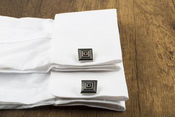 cufflinks with shirt on the wooden background. cufflink concept.