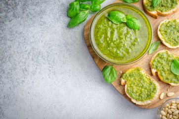 Pesto sauce and sliced bread on a wooden board