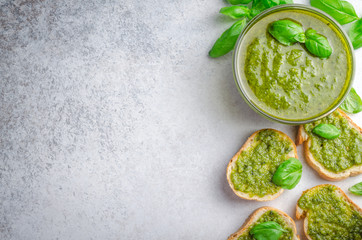 Pesto sauce and sliced bread on a stone table