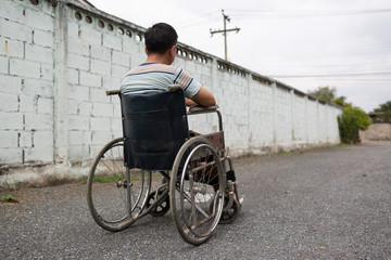 Young man sitting on wheelchair, Disabled concept outdoor.