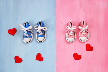 Baby sneakers on pink and blue background, baby shower concept