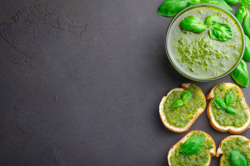 Pesto sauce and sliced bread on a stone table