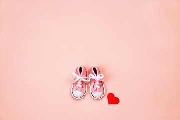 Baby sneakers on pink background
