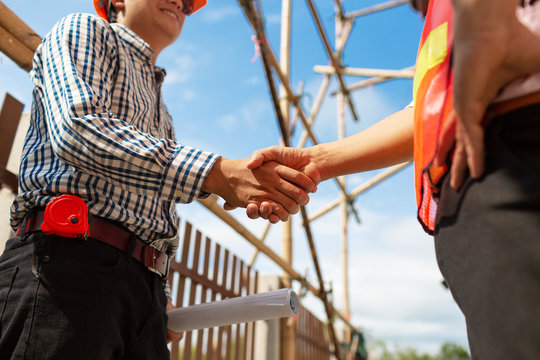 Engineer Contractor Shaking Hands At House.