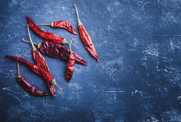 Dried chili peppers on blue concrete background