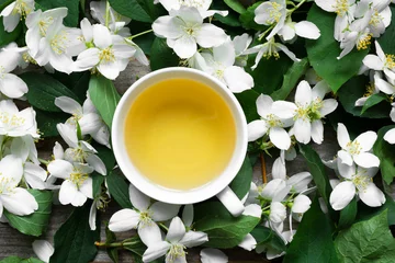 Cercles muraux Theé Cup of green jasmine tea on jasmine flowers background