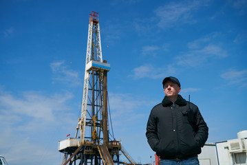 Security guard with walkie talkie, controlling outdoor oil drilling rig station platform. Safety...