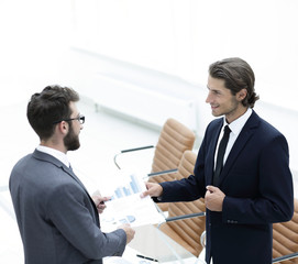 two businessmen talking in the office.