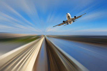 Fototapeta na wymiar Airliner over highway on blurred background