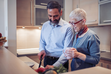 Romantic mature couple cooking together in the kitchen