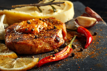 Beef steak with mashed potatoes, spices and sauce.