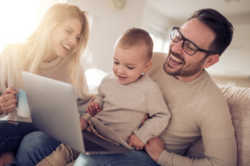 Happy young family watching movie at home