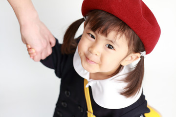 お母さんと手を握る幼稚園の制服の幼児(3歳児)