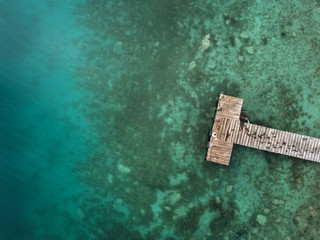 Wooden pier and turquoise water from above