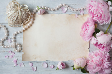Pink peonies and roses on a wooden background