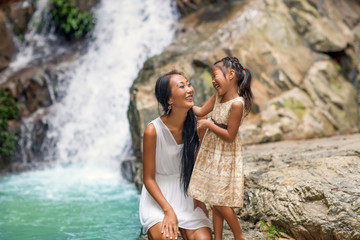 happy mother with her daughter in the tropics near the waterfall. Mothers day.