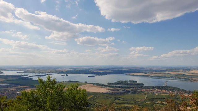 Stunning timelapse landscape view of dam lakes Nové Mlýny and vineyards fields with smoke white clouds passing above near Pavlov in Pálava region in South Moravia during late summer day