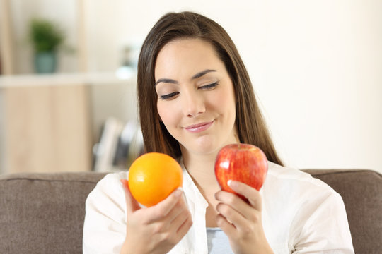 Girl deciding between two fruits