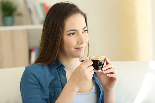Relaxed woman drinking coffee and looking at side