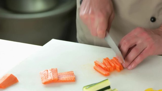 Hands of man cutting carrot. Fresh sweet vegetable.