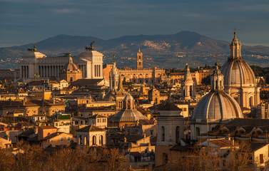 Fototapeta na wymiar View of Rome historic center at sunset with baroque domes and Capitoline Hill