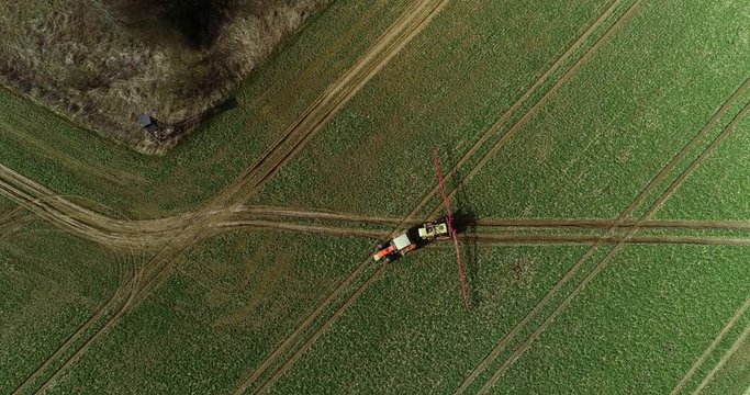 Tractor spray fertilize on field with chemicals in agriculture field.