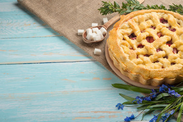 Homemade pie with flowers on a wooden background. With an empty place for the inscription.