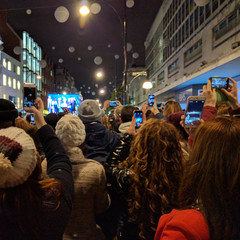 Obraz premium People taking photos of people taking photos of a big screen of people taking photos..