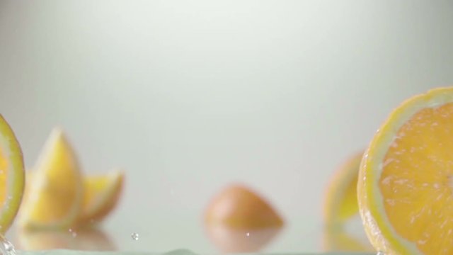 rolling orange fruit slices on white background . Slow motion shot