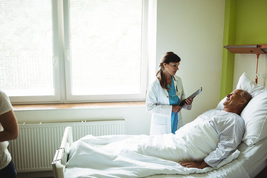 Female Doctor Talking With Senior Man In Hospital