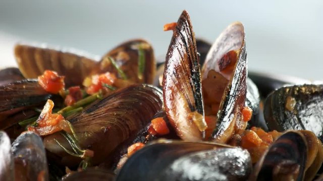 Mussels with vegetables and rosemary. Steamed clams macro.