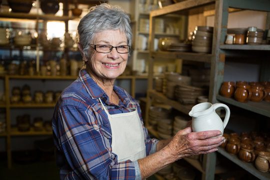 Portrait of female potter holding jug
