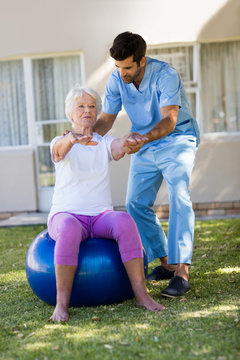 Nurse helping senior woman doing exercices