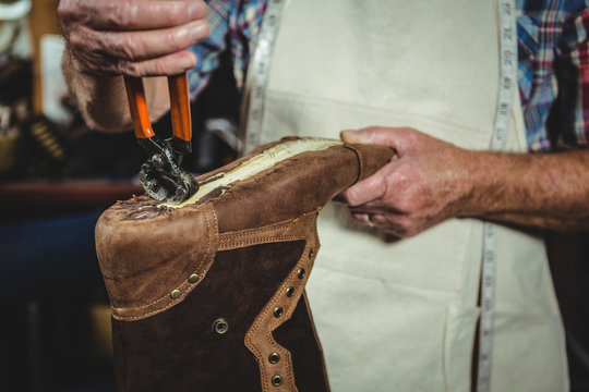 Mid section of shoemaker repairing a shoe