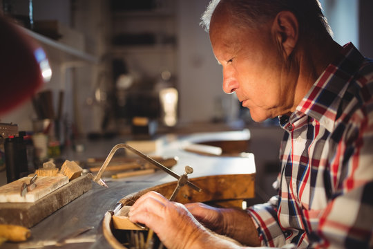 Goldsmith shaping metal with coping saw