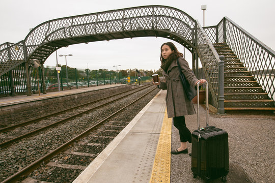 Woman waiting for the train with luggage
