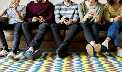 Group of people using mobile phone on couch