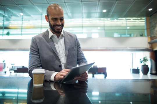 Businessman using digital tablet in waiting area