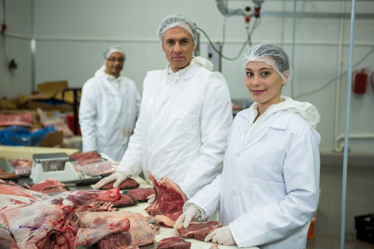 Butchers standing at meat factory