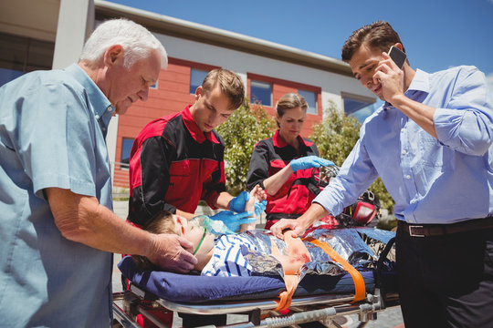 Paramedics examining injured boy