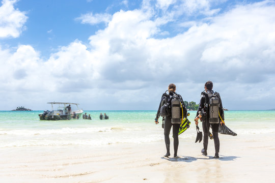 Divers Walking on Beach in Seychelles.