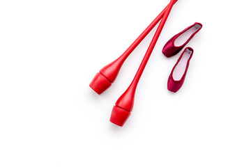 Beauty sport for girls concept. Maces for rhythmic gymnastics and ballet shoes on white background top view copy space