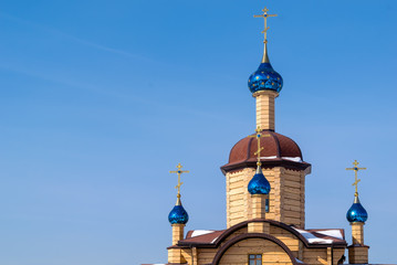 Fototapeta na wymiar beautiful wooden Church with blue domes with stars