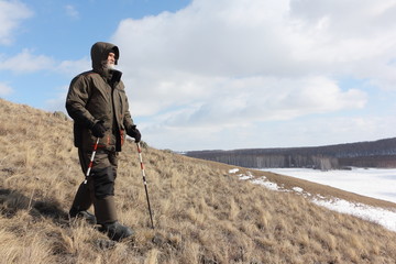 Nordic Walking -  adult man descending from the mountain Bald, Bugotaksky hills, Novosibirsk...