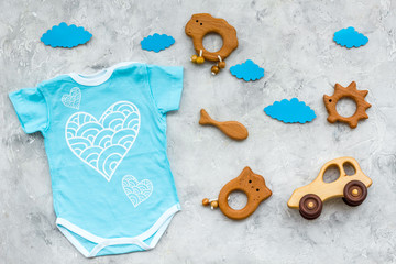 Newborn baby's sleep concept. To put the child to bed. Baby bodysuit near clouds and toys on grey...