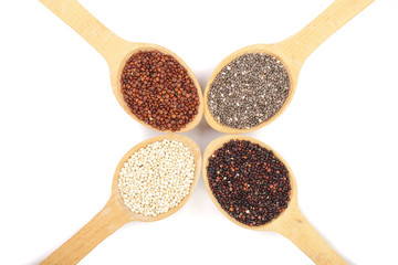Black red white quinoa and chia seeds in wooden spoon isolated on white background. Top view